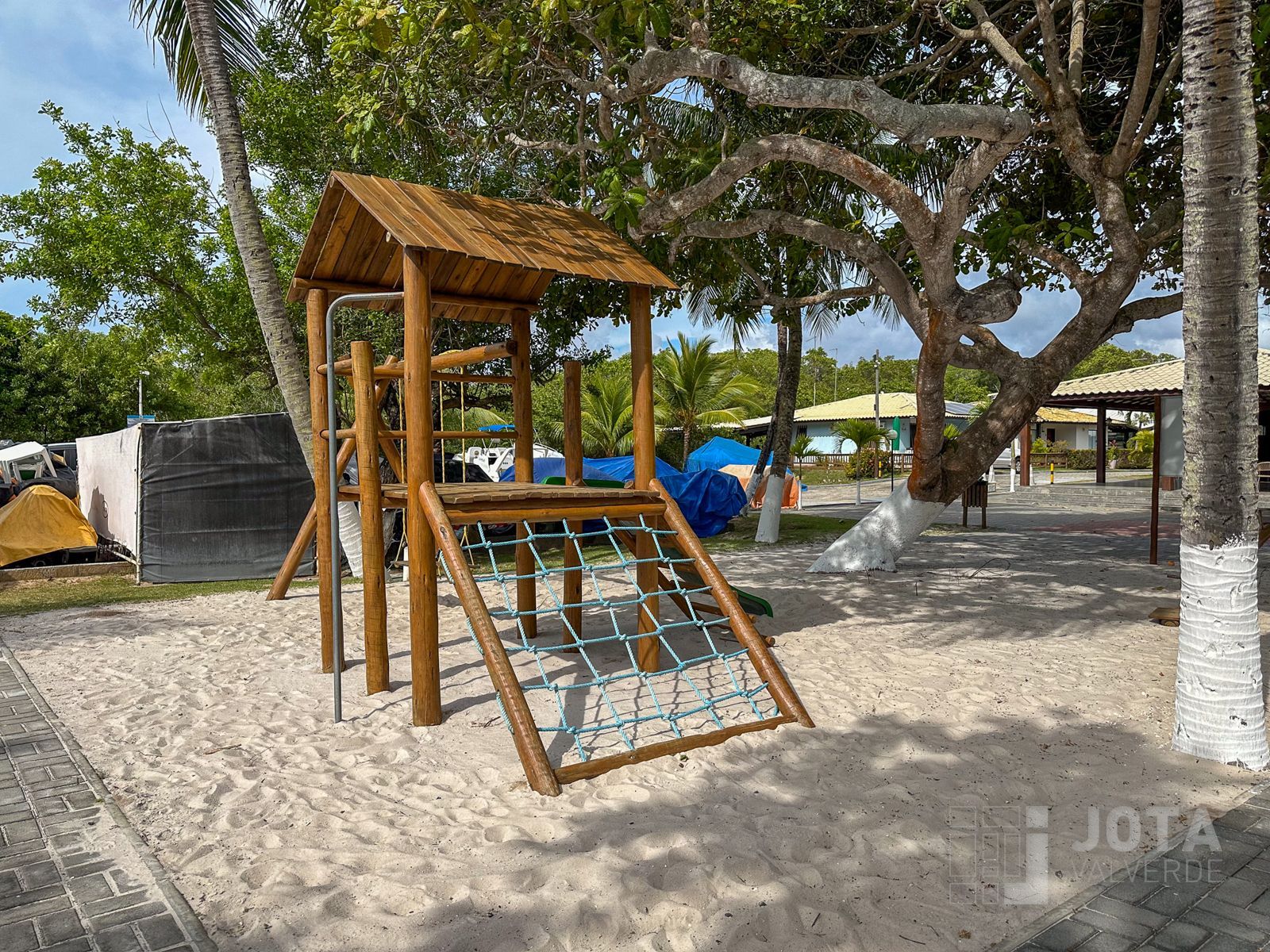 Parque infantil na areia, sob as árvores do condomínio
