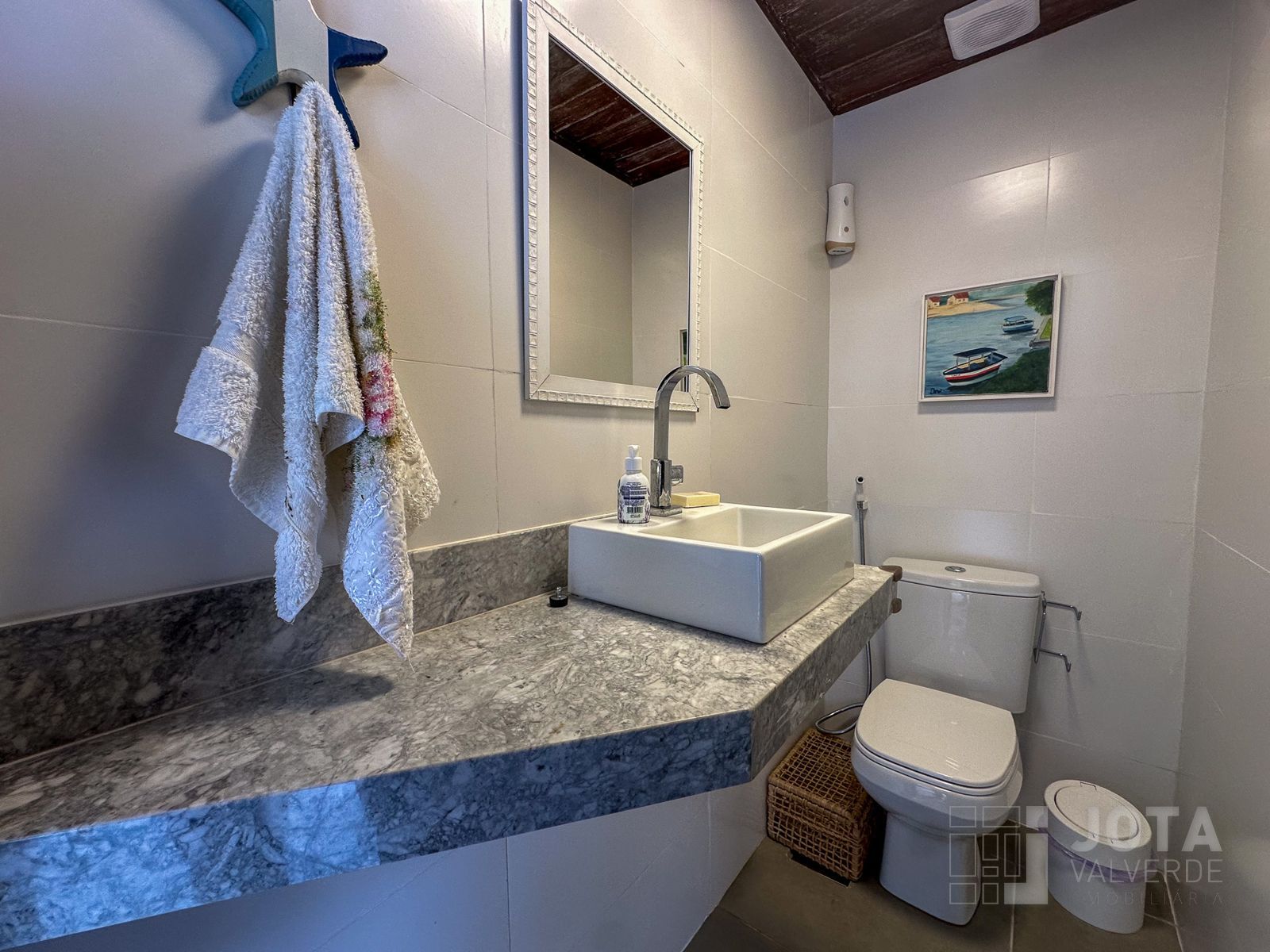 Lavabo social com bancada em mármore e decoração náutica